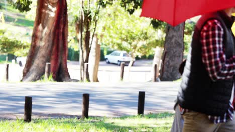 family walking together in park with umbrella