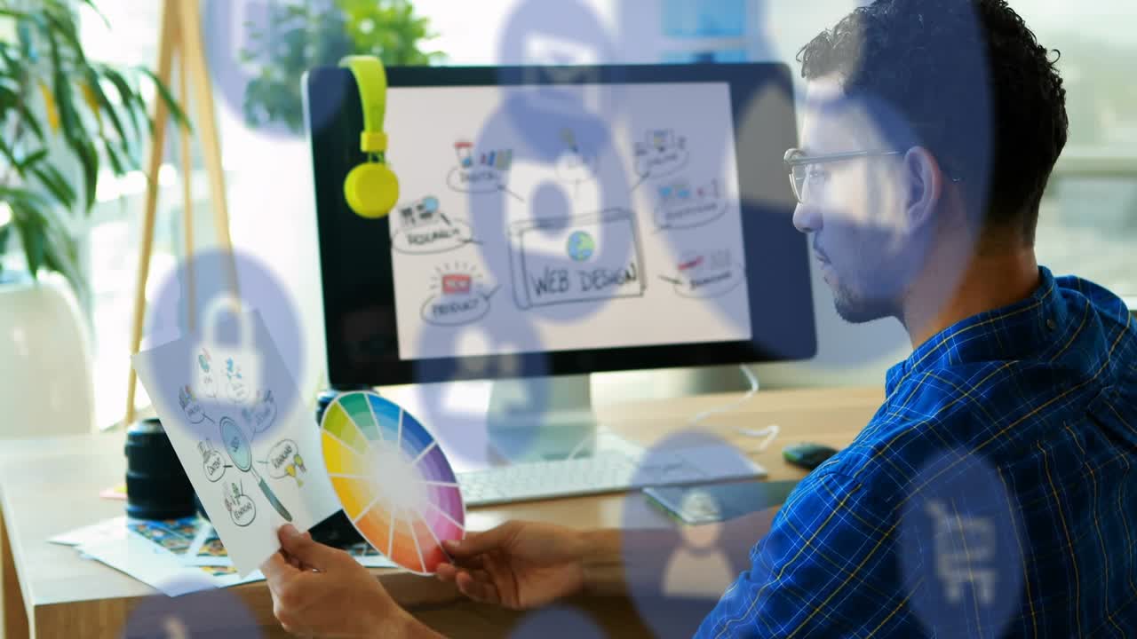 Animation of digital icons over male graphic designer holding a document and color swatch