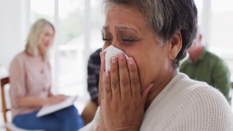dos parejas de ancianos diversos sentados en círculo teniendo una conversación de terapia en casa