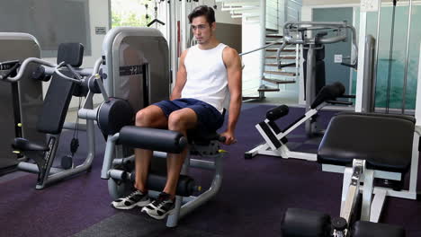 fit man exercising his legs on weight machine