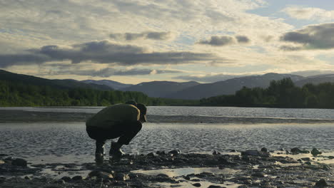 el hombre saboreando el agua fresca de los lagos de montaña, la serenidad ártica en el norte de europa