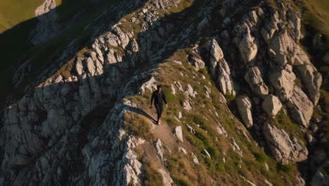 person hiking a steep mountain ridge