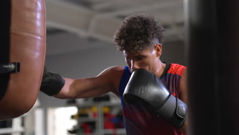 hombre entrenando en bolsa de boxeo en el gimnasio