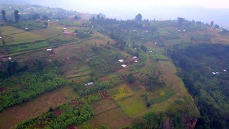 aerial view of kapchorwa’s terraced farmlands on the slopes of mount elgon, uganda. scattered homes and crops reveal the region’s highland agriculture and athletic training heritage.