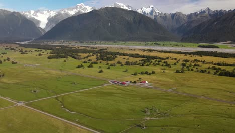 drone reveal of new zealand farmland and majestic mountain alpine scenery