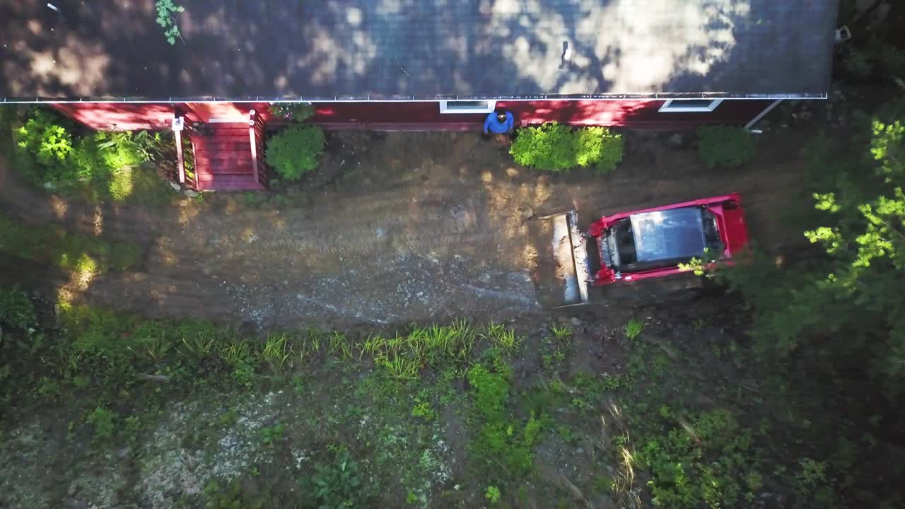 Aerial view of a red house with a tractor