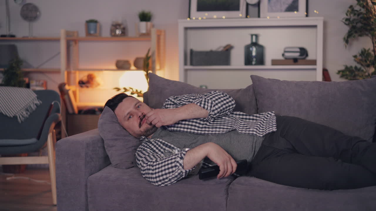 소파에서 tv를 보고 휴식을 취하는 남자