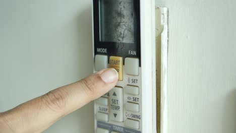 persona que utiliza el control remoto del aire acondicionado