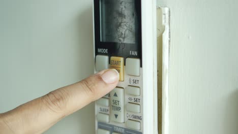 person using air conditioner remote control