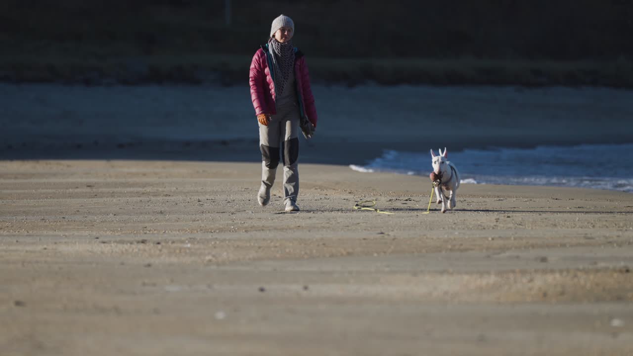 Una donna che cammina sulla spiaggia sabbiosa