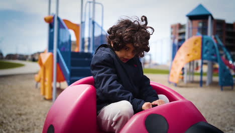 young boy getting dizzy in a playground at a neighbourhood park