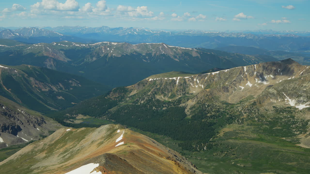 panorámica cinematográfica a la izquierda grises y torres 14er montañas rocosas picos de colorado breckenridge paisaje soleado verano pacífico cielo azul nubes rodando nieve impresionante en la parte superior hermosa mañana amplia