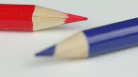 wooden red and blue colored pencil on white surface - arts and craft equipment - rack focus