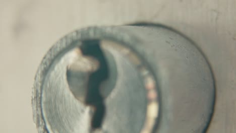 Macro-zoom-out-video-of-a-keyhole,-silver-door-lock