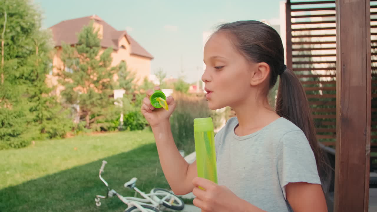 Cute Girl Blowing Soap Bubbles Outdoors
