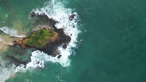 Toma-Aérea-Cenital-Sobre-El-Mar-Y-La-Playa-De-La-Roca-Del-Loro,-Mirissa,-Sri-Lanka-Al-Amanecer