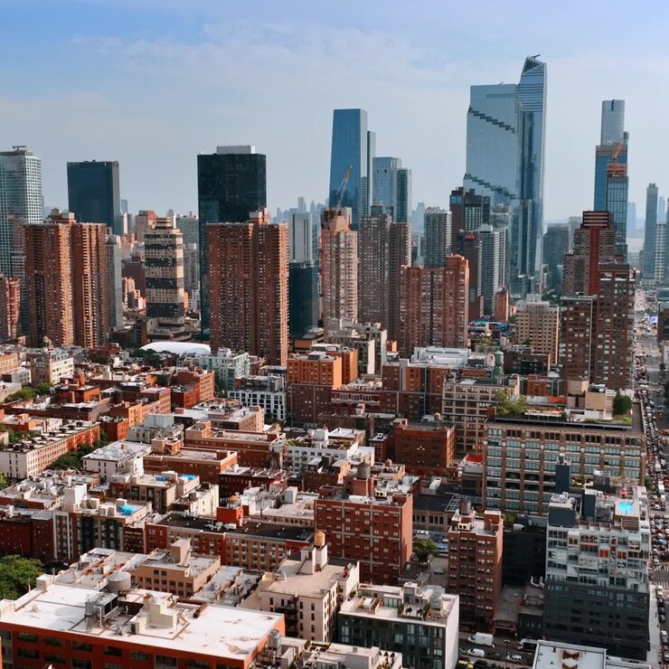 Un edificio ordinario in contrasto con splendidi grattacieli. Volo di drone sopra New York in una giornata di sole