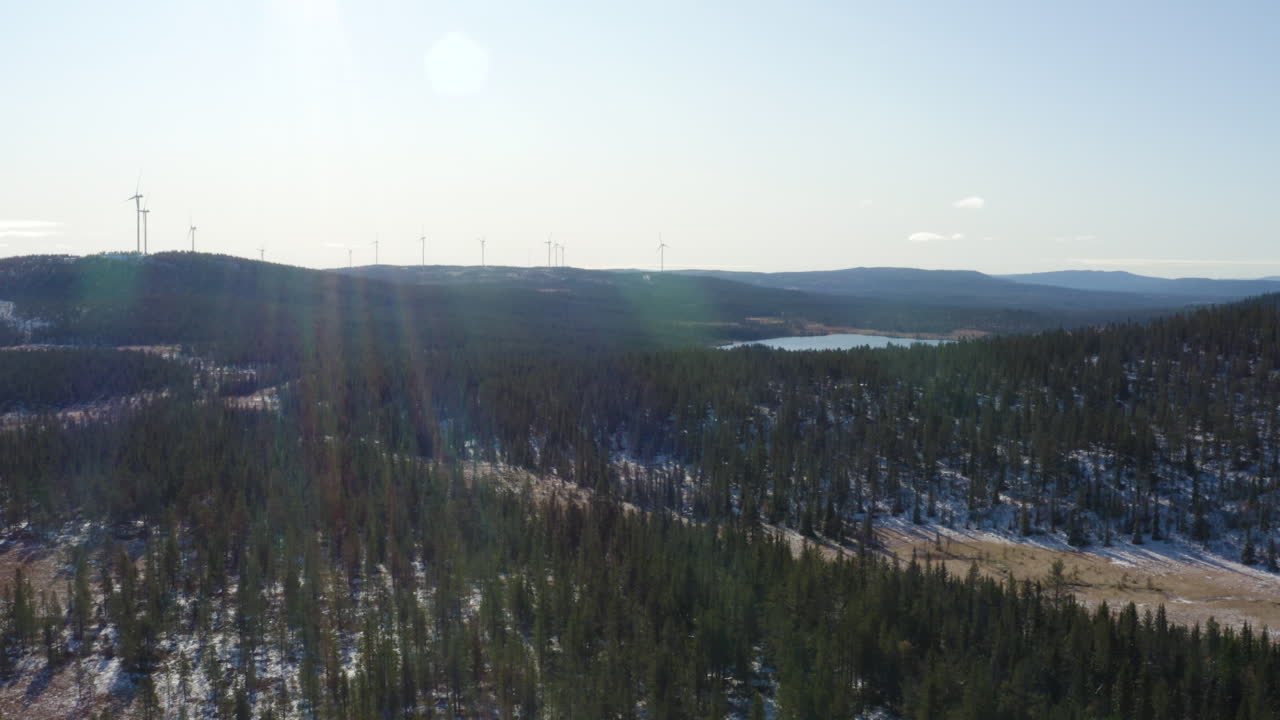De mäktiga vindkraftverken i Osen, Norge, under en klarblå himmel och moln, belägna vid fält med träd - Flygfoto