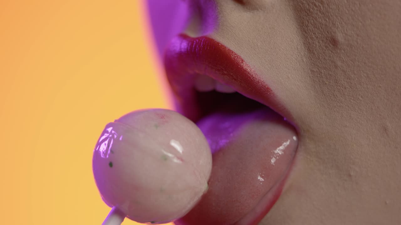 donna che leca il gelato, leca il rossetto, le labbra, la bocca in primo piano su sfondo giallo