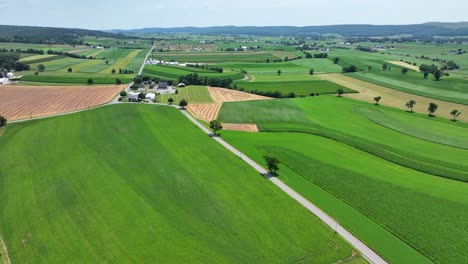 a panning aerial view of the lush green rural countryside and farmlands of southern lancaster county, pennsylvania