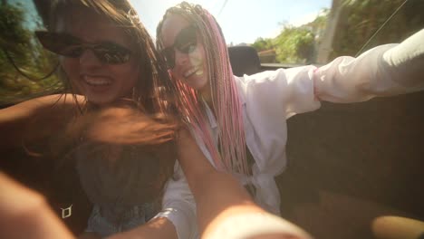 two young women enjoying a sunny road trip in a convertible