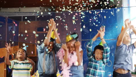 animation of confetti over happy diverse children having fun with balloons at birthday party