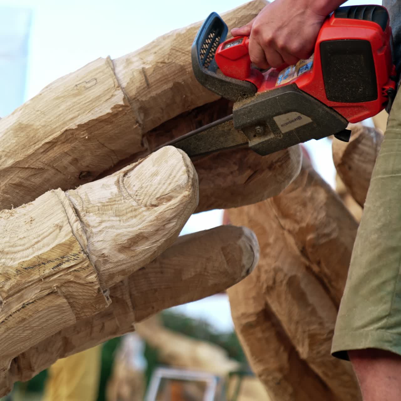Wooden sculpture making. Chainsaw art creating handsome man