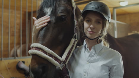 woman petting a horse in a stable
