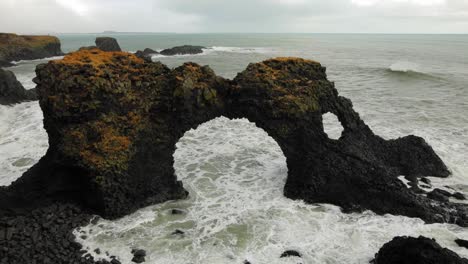 The-beautiful-black-arch-rock-formation-at-diamond-beach-by-the-sea-in-Iceland---wide-shot