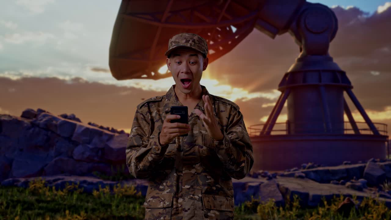 Asian Man Soldier Looking At Smartphone, Smiling, And Saying Wow While Standing With Satellite Dish