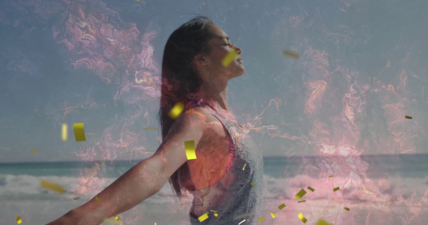 Woman extending arms inhaling on beach generating confetti swirling pink flames for technology
