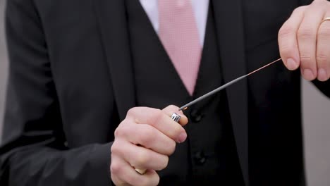 man in suit lighting sparkler, close-up of hands, selective focus