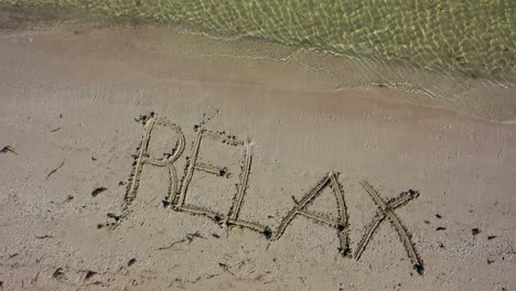 Static-shot-of-RELAX-written-in-the-sand-at-an-angle