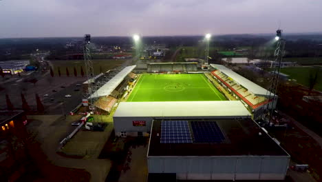 Pluma-Aérea-Abajo-Del-Campo-De-Fútbol-Iluminado-En-Emmen,-Países-Bajos