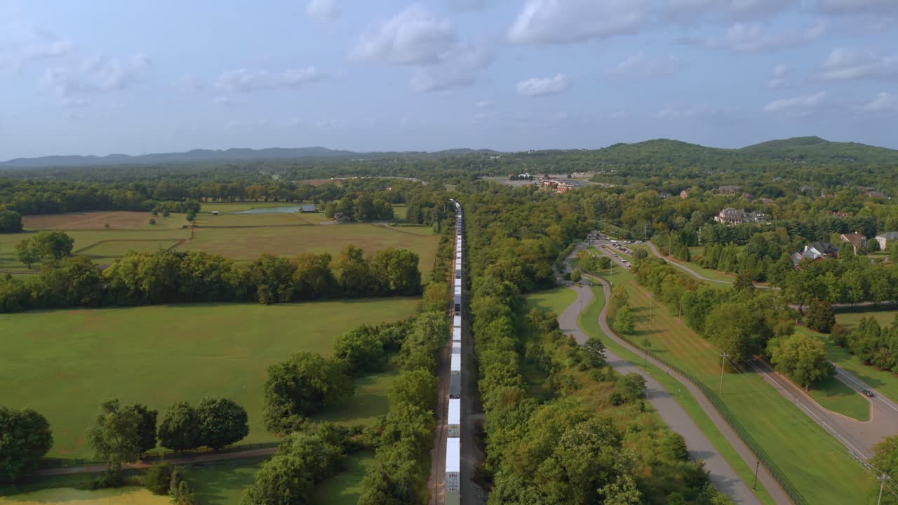 tren de carga corriendo en el drone filmando desde arriba en tennessee con muchos árboles verdes y follaje alrededor