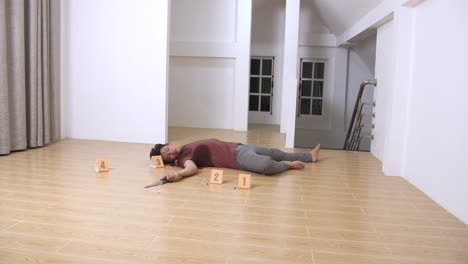 dead man body and knife in blood lying on floor at crime scene