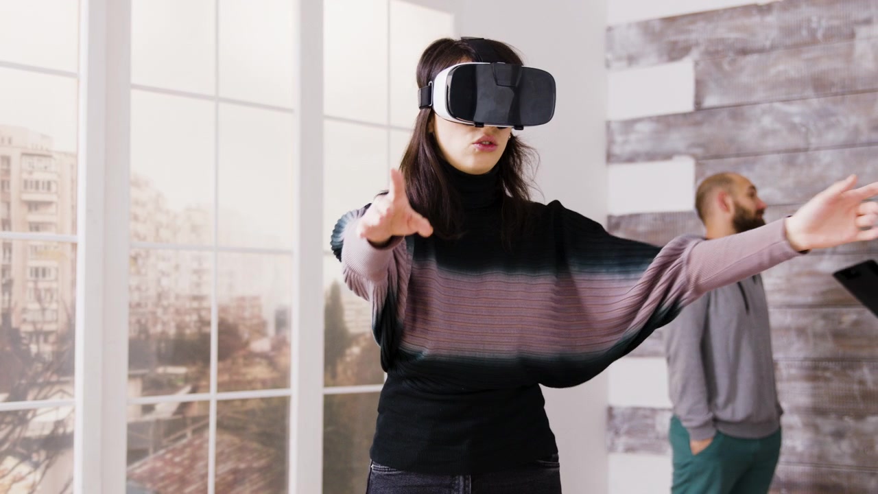Giovane donna che testa un visore per la realtà virtuale in un ufficio moderno.