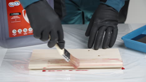 applying wood stain to a plank