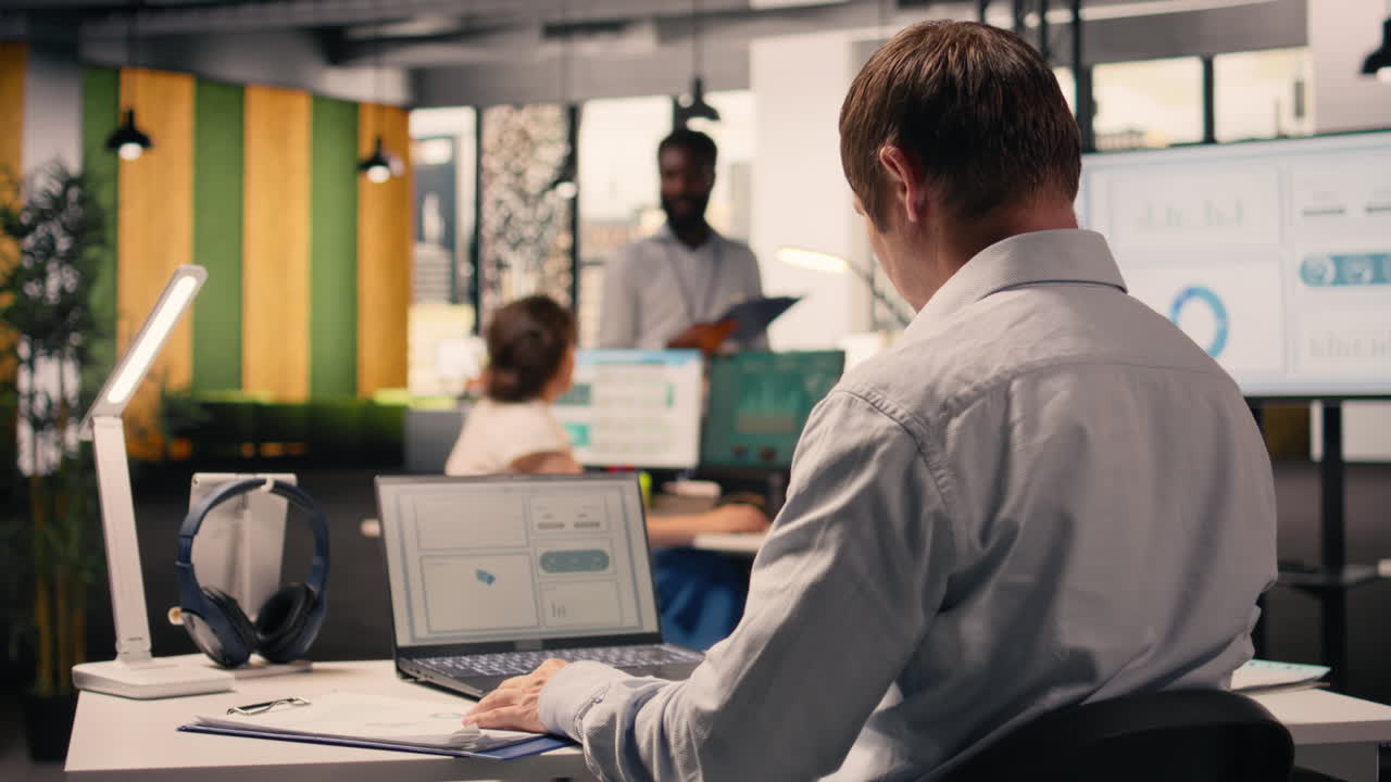 Professional worker reviewing compliance data on laptop screen at desk