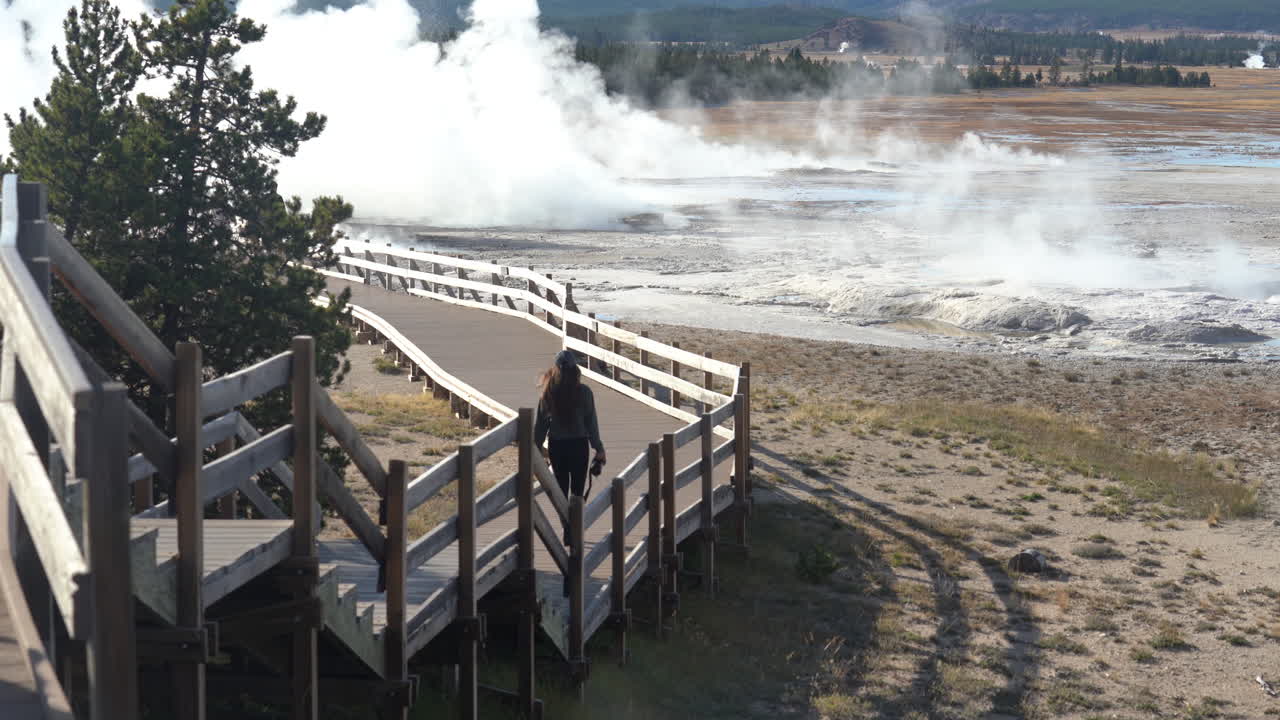 mujer caminando por el camino de los géiseres del parque nacional de yellowstone, wyoming, estados unidos, fotograma completo