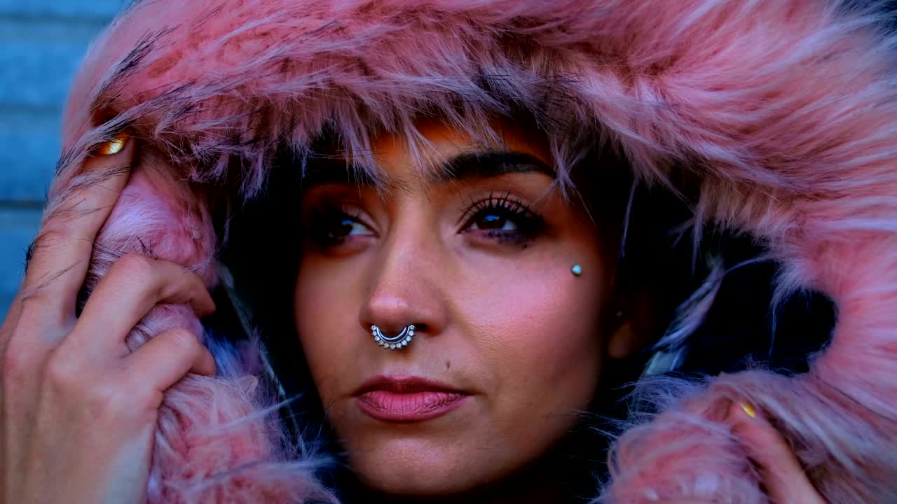 Woman with nose ring and fur jacket standing outside the shop 4k