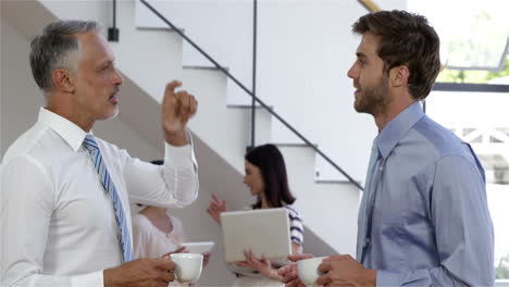 Businessman-drinking-a-coffee-together-while-businesswoman