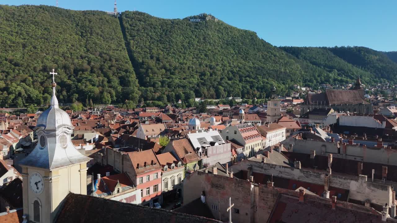 Vista aerea di una città storica con montagne e cielo sereno, atmosfera tranquilla