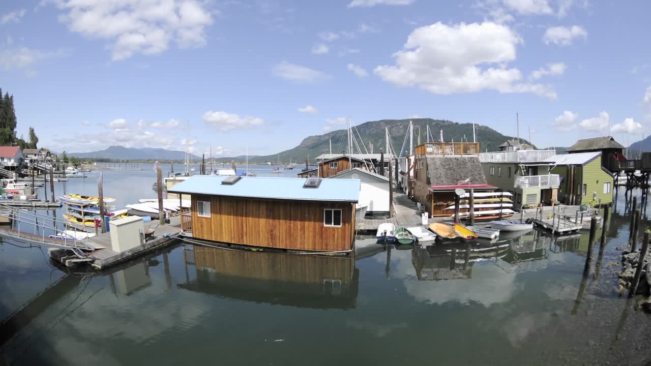 캐나다 브리티시 컬럼비아 밴쿠버 섬의 코위찬 만에 있는 부두와 보트 위를 지나가는 구름의 시간 경과