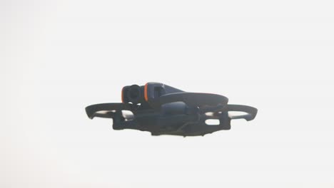 drone fpv con protectores de hélice incorporados flotando en un cielo brillante, chequia
