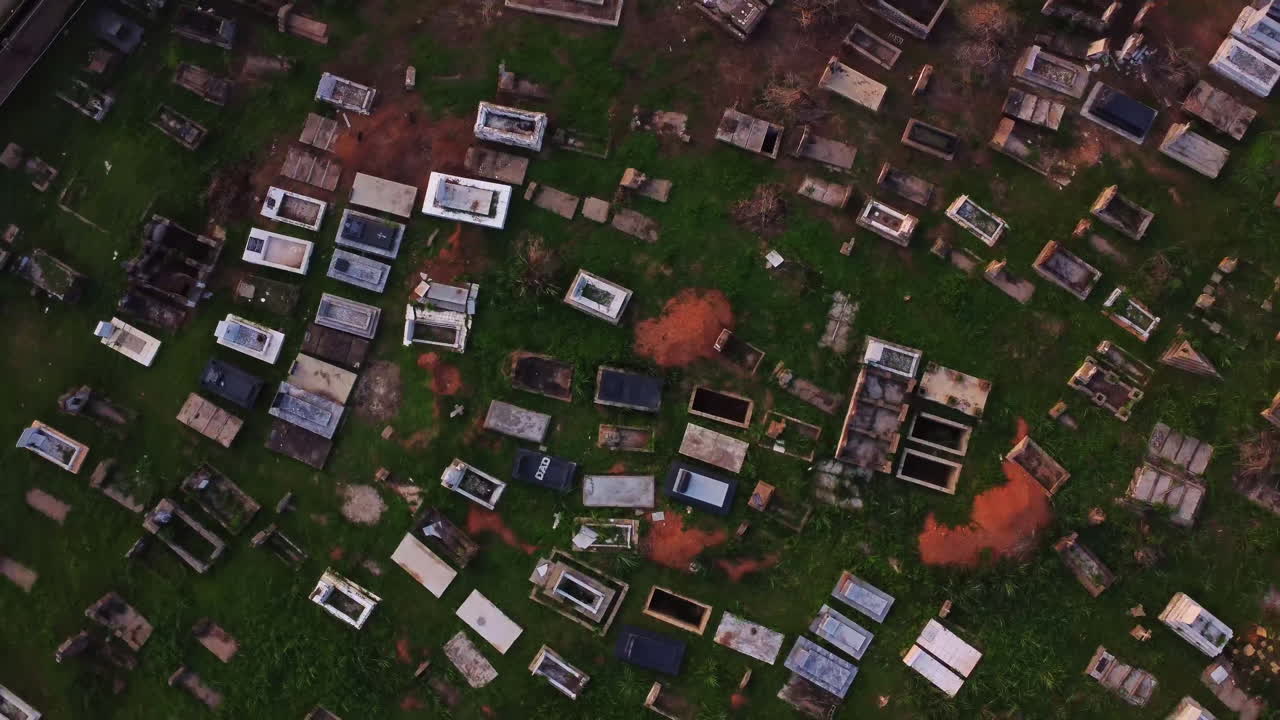 Top down view of a large cemetery in Nigeria, Africa. The drone spins frantically over the graves