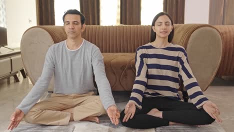 middle aged indian couple doing meditation