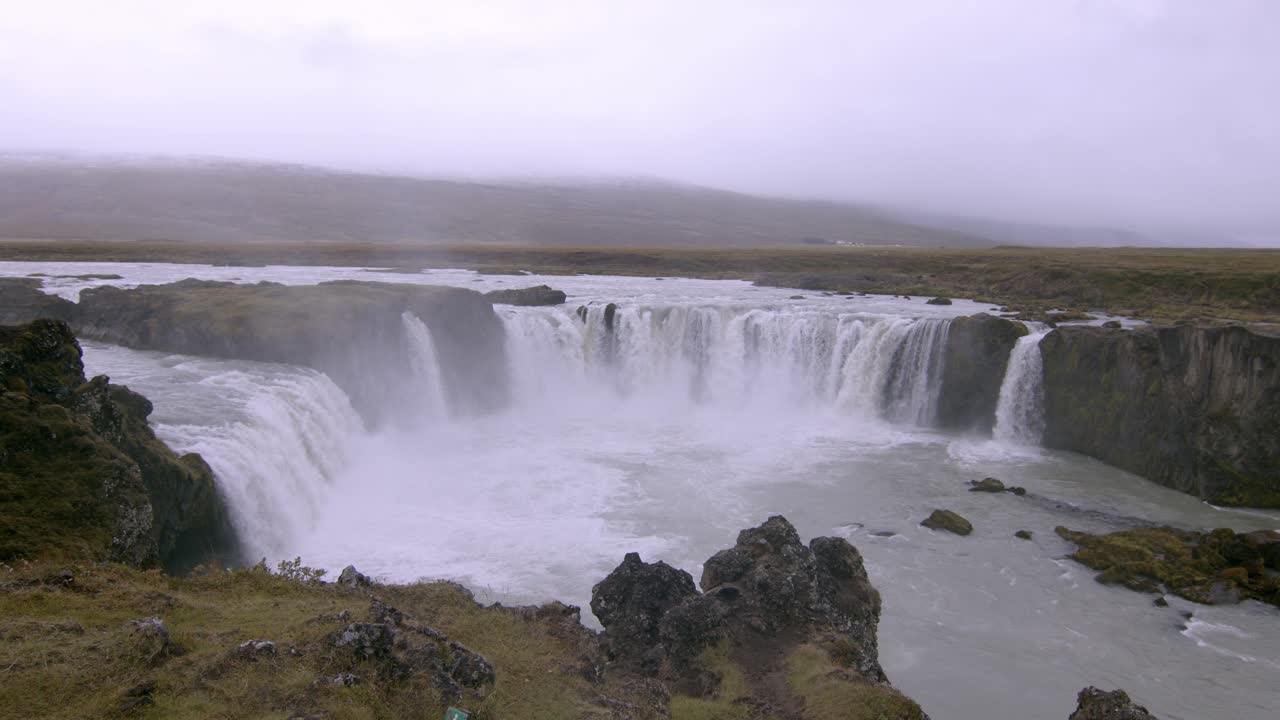 Majestic view of the powerful Godafoss waterfall flowing over rocky cliffs in Iceland