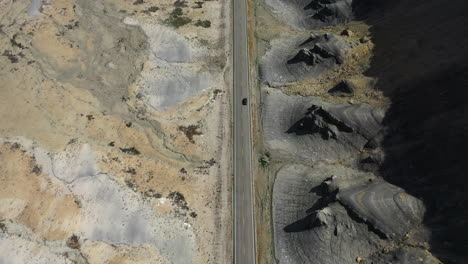 Aerial-tilt-shot-fracking-a-car-a-desert-road-in-middle-of-sunny-southwest-USA