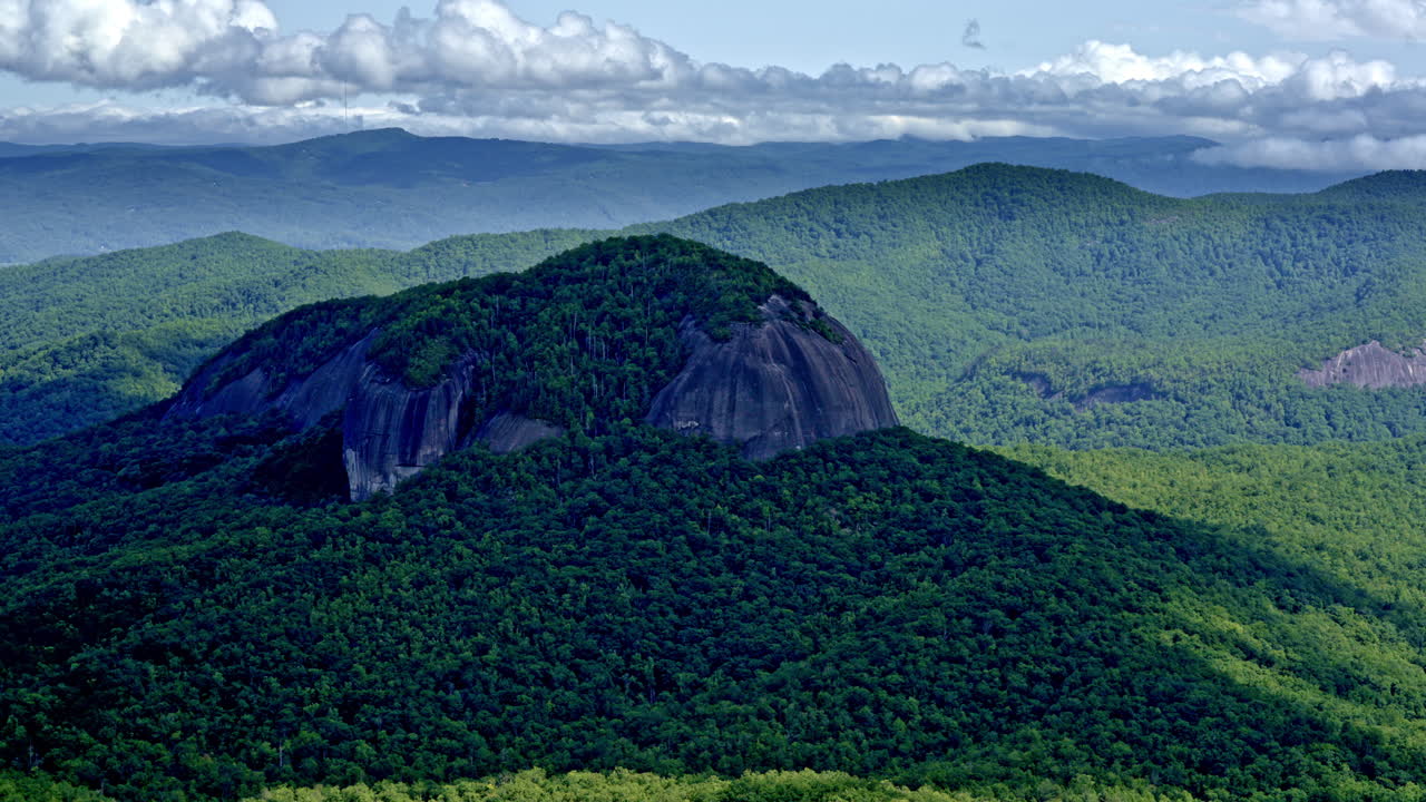 Lone mountain peak dramatically rises away from the surrounding ridges — aerial view